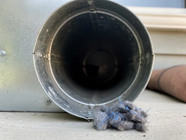 Littleton Dryer Vent Cleaning technician using specialized equipment to clear severe dryer vent blockage in Littleton